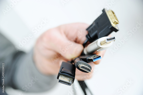 The  various cords and plugs in the hand.