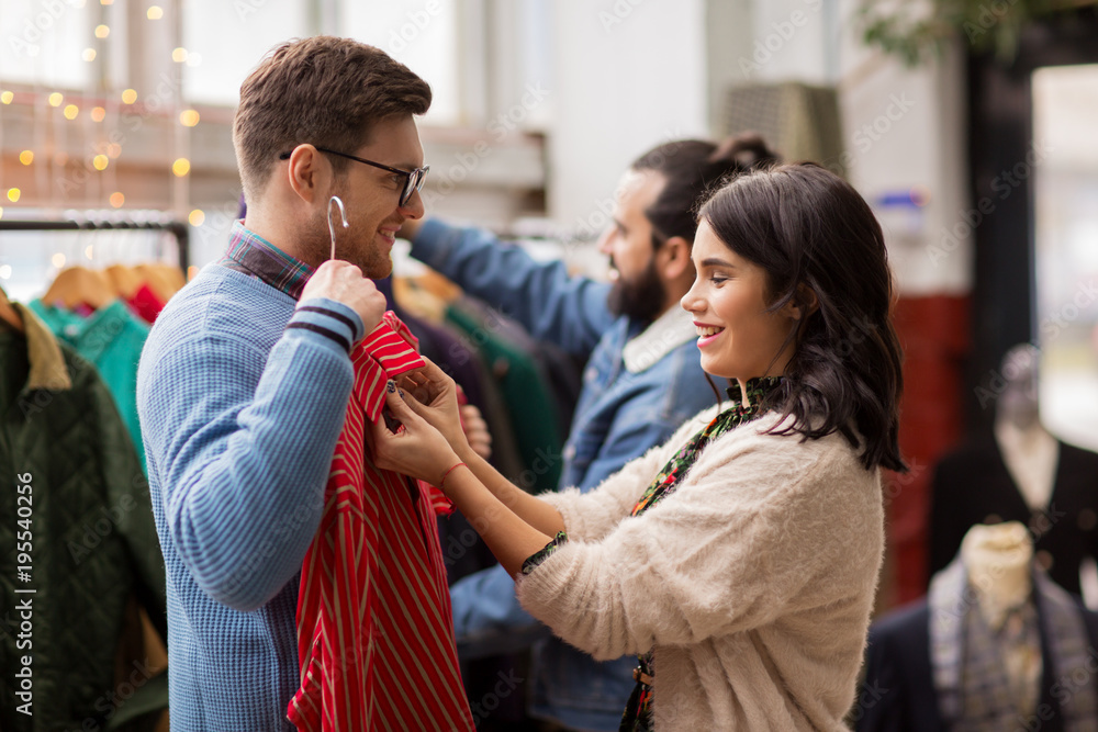 Fototapeta premium couple choosing clothes at vintage clothing store