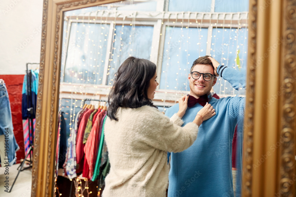 Fototapeta premium couple choosing bowtie at vintage clothing store