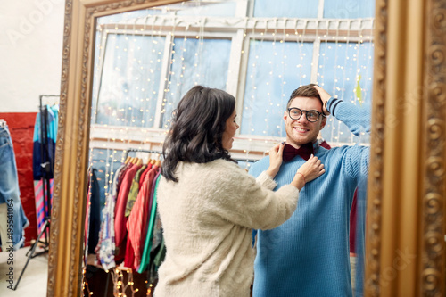 couple choosing bowtie at vintage clothing store