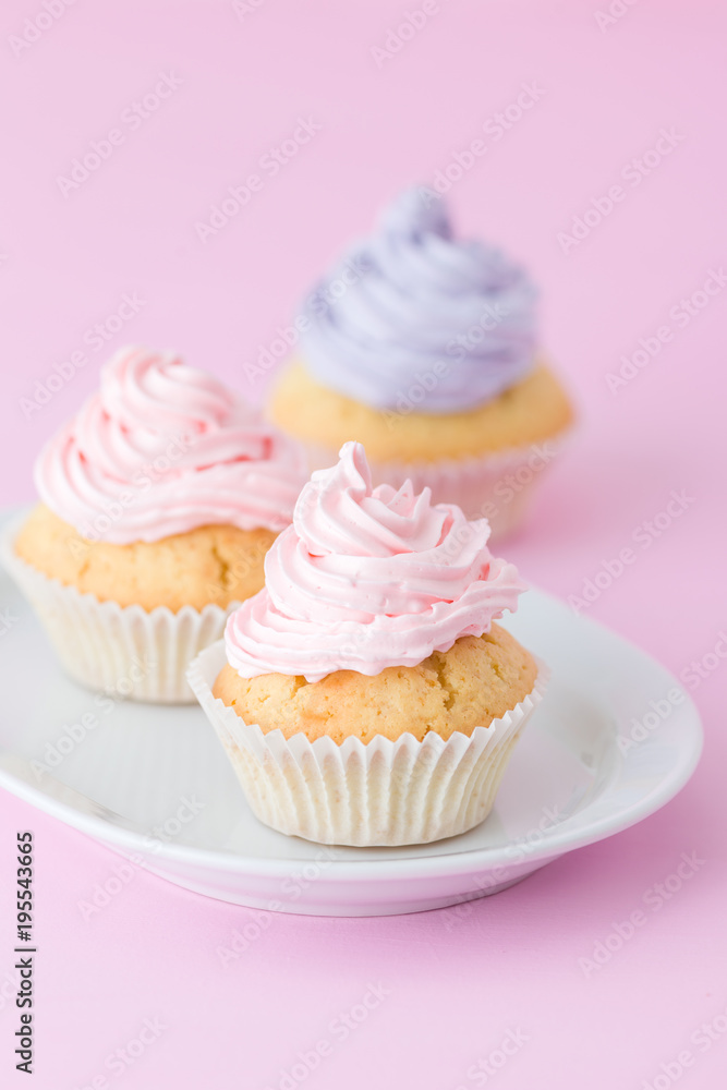 Cupcake decorated with pink and violet buttercream on pastel pink background. Sweet beautiful cake. Vertical banner, greeting card for birthday, wedding. Close up photography. Selective focus