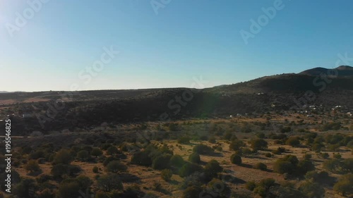 Aerial panning shot of a road winding through some beautiful desert mountains 
