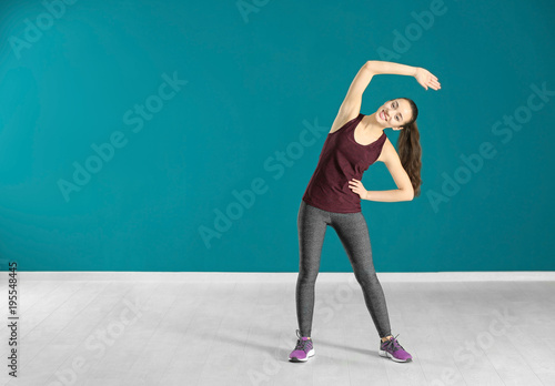 Beautiful young woman doing fitness exercise at home