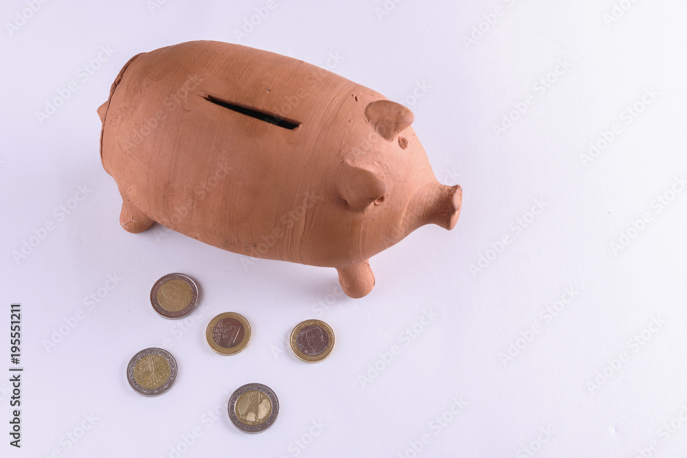 brown mud piggy bank viewed from above and five euro coins on the