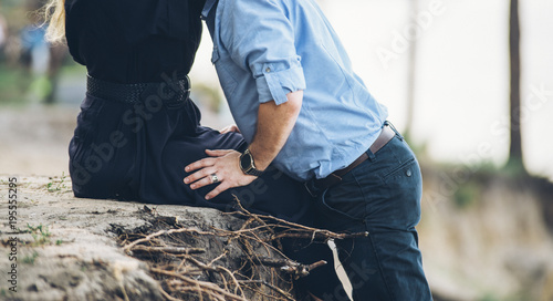 couple is hugging on the hill near the river