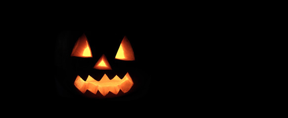 Halloween pumpkin with scary face on black background.