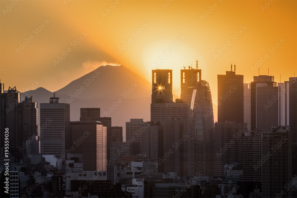 Tokyo Shinjuku building with Top of mountain fuji at sunset in winter season. Mount Fuji lies about 100 kilometres south-west of Tokyo, and can be seen from there on a clear day.