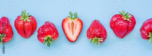 Fototapeta Naklejka Na Ścianę i Meble -  raw of fresh juicy strawberries on blue background. flat lay top view