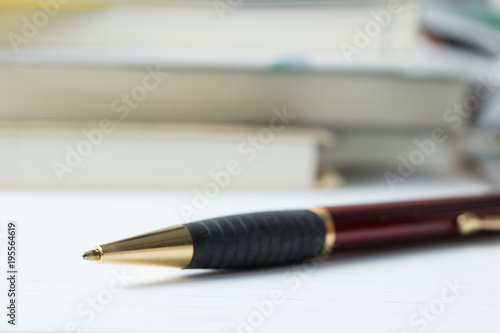 ボールペンと積まれた本