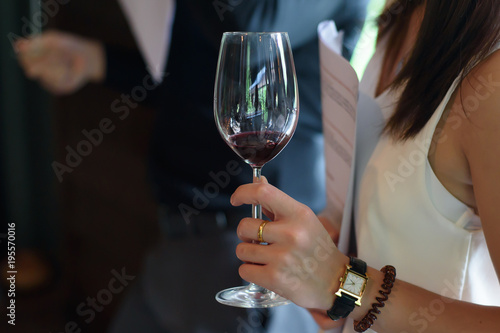 Woman holding a glass of wine at a party.
