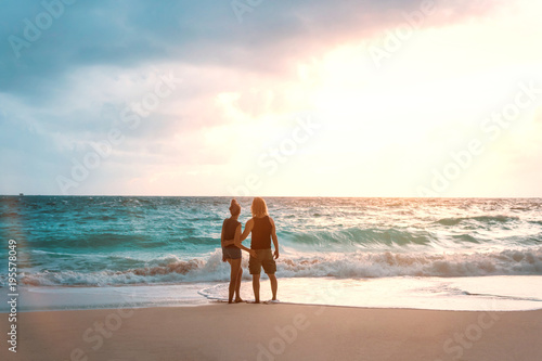 Honeymoon couple in love embracing and enjoying ocean view at beach