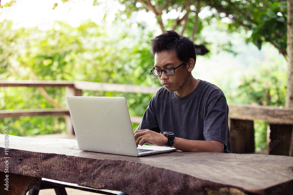 A man is working using laptop at park / outdoor cafe A man is working using laptop at park / outdoor cafe