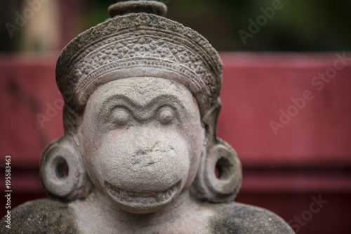 Cambodian monkey looking mythical creature grey stone sculpture with two ear loops