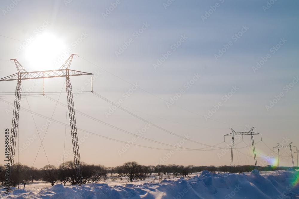 electric power lines in winter during the sunset