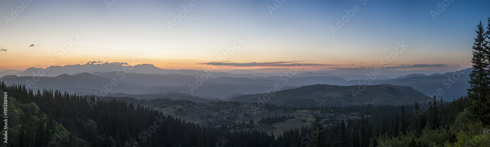 Fototapeta premium Sunset panorama landscape of mountains with forests