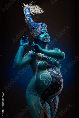 Canvas Print Beautiful pregnant woman with headwear and abstract body art in shades of blue a
