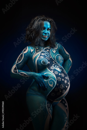 Canvas Print Beautiful pregnant woman with headwear and abstract body art in shades of blue a