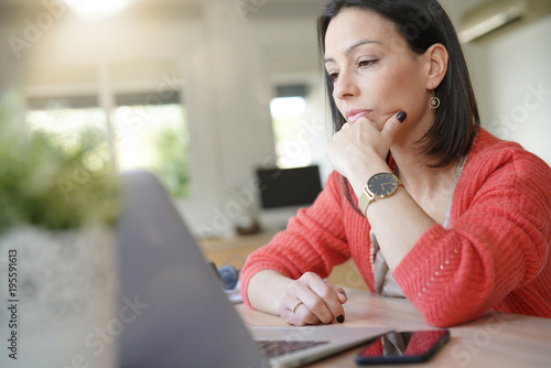 фотографія Brunette girl being thoughtful in front of laptop