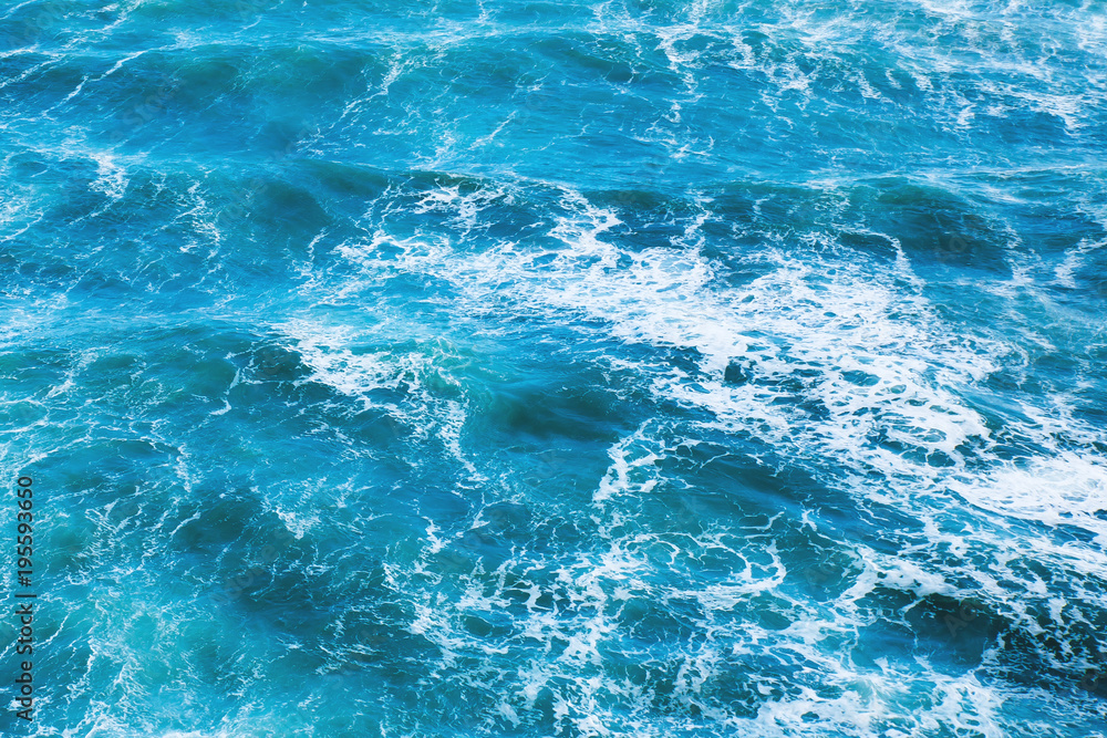 Blue sea water with waves and white foam for background.