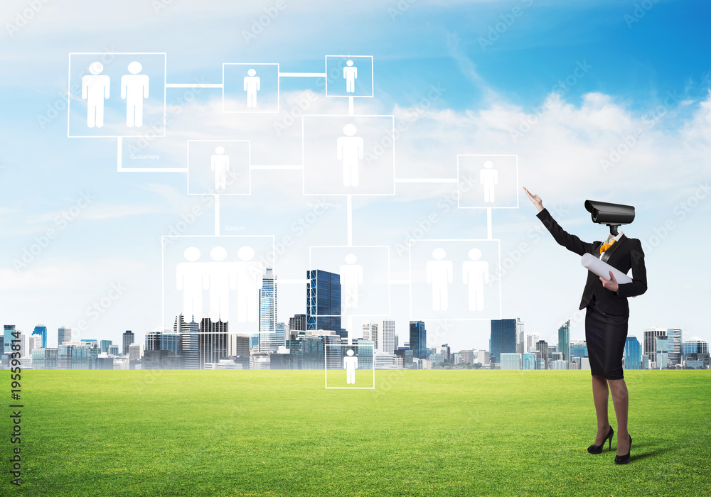 Camera headed woman standing on green grass against modern cityscape