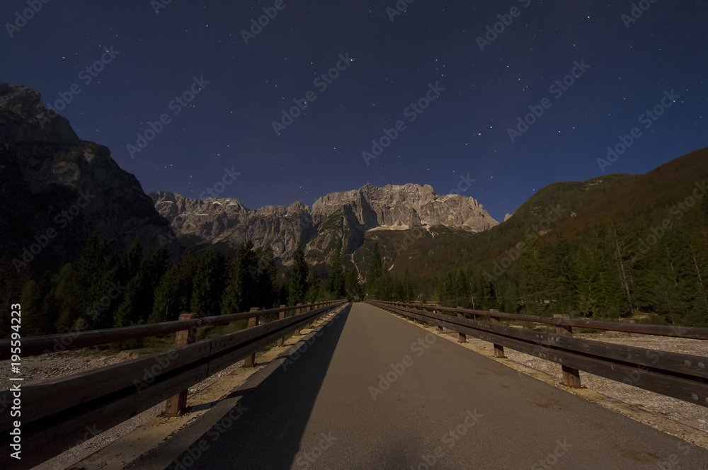 Julien Alps mountain scene under the moonlight. night road in foreground