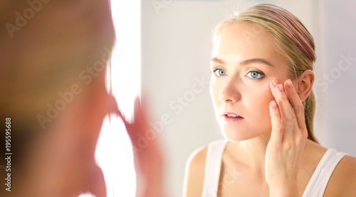 face of young beautiful healthy woman and reflection in the mirror