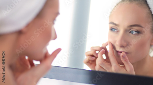 face of young beautiful healthy woman and reflection in the mirror