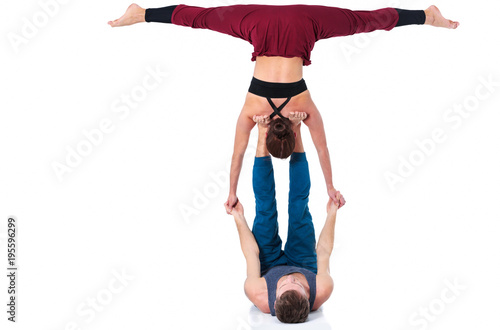 Young athletic couple practicing acroyoga. Balancing in pair photo