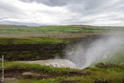 Gullfoss Waterfall, Iceland - July 19, 2017: Helicopter over the canyon of Hvita river on a cloudy day. Iceland