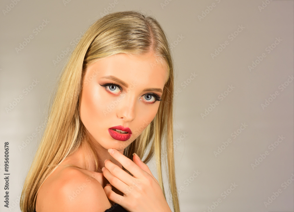 Beautiful blonde girl touching her face. Pretty sexy girl, cute woman with  long hair, red lips, professional makeup, perfect skin. Stylish attractive  model with beautiful face. Beauty, spa. Copy space Stock Photo