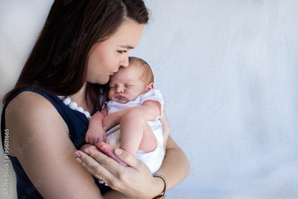 Mother holding sleeping newborn baby close together Mother holding sleeping newborn baby close together