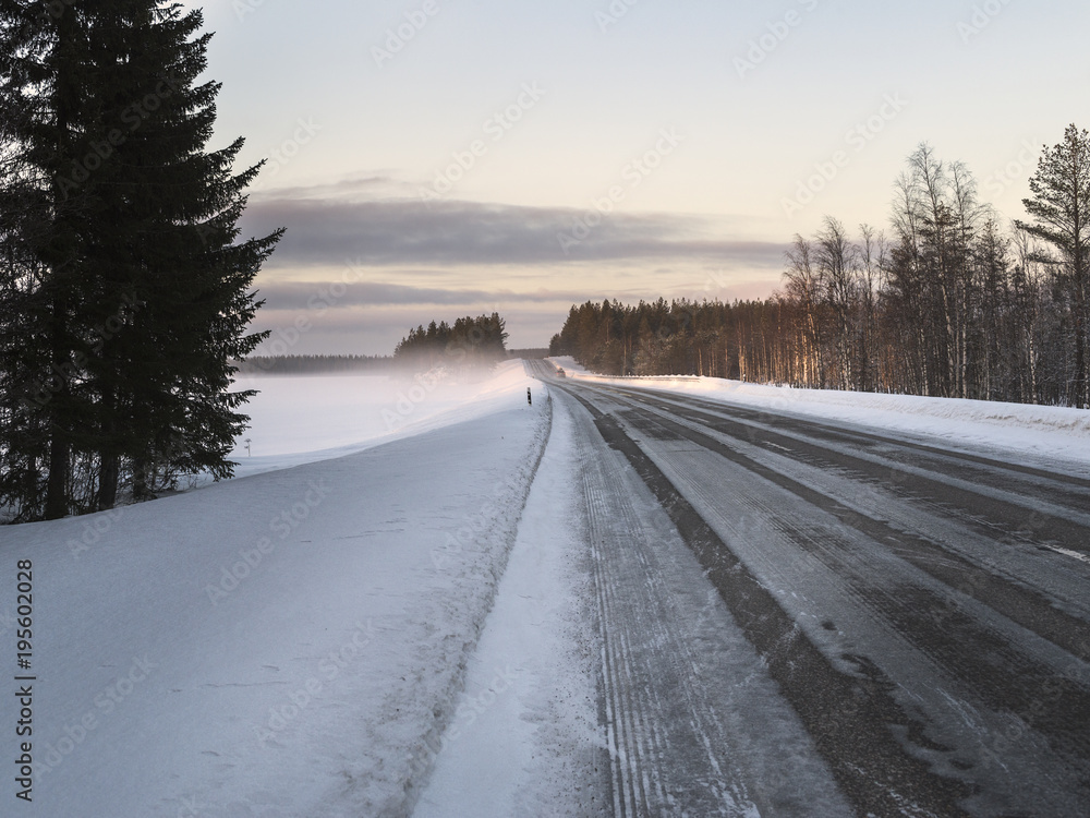 Winter road through snowy fields and forests Winter road through snowy fields and forests