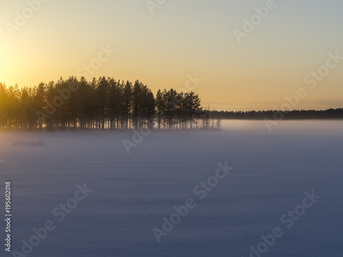 Winter landscape.Sunset on the frozen lake in the woods. 