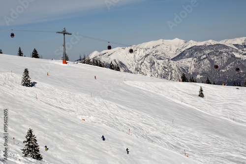 People skiing down the slope. Ski slope in winter sunny day at the mountain ski resort of Alpbachtal, Wildschonau, Austria photo