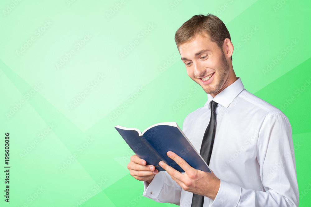 Handsome young business man reading a book Handsome young business man reading a book