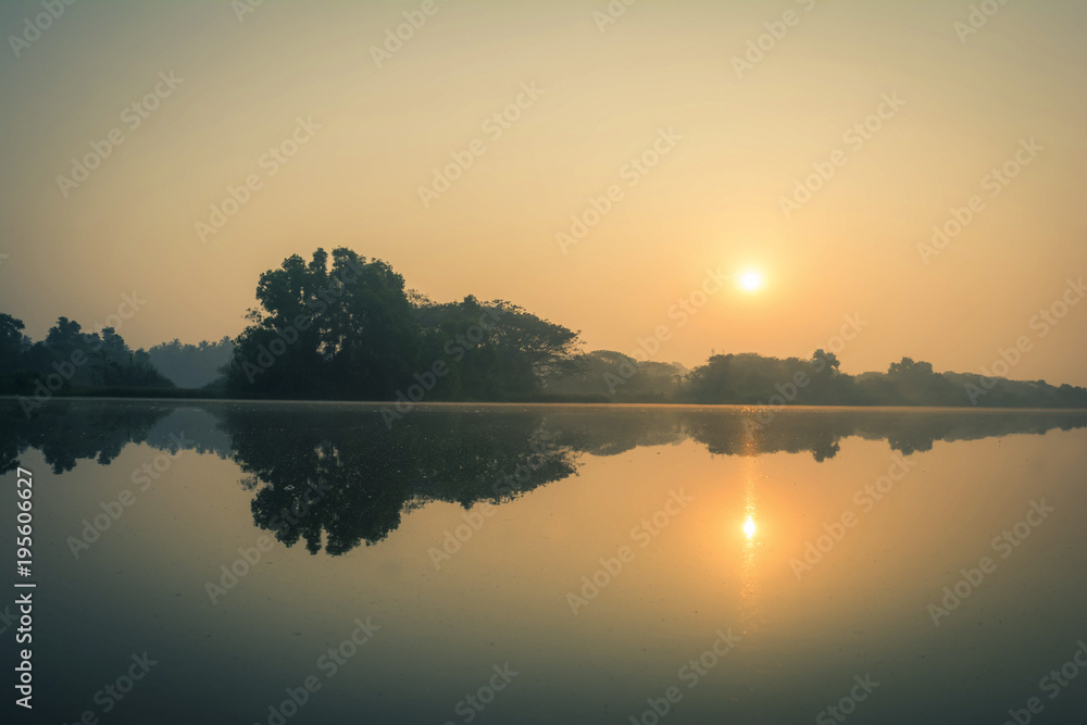 sun rising over a calm river