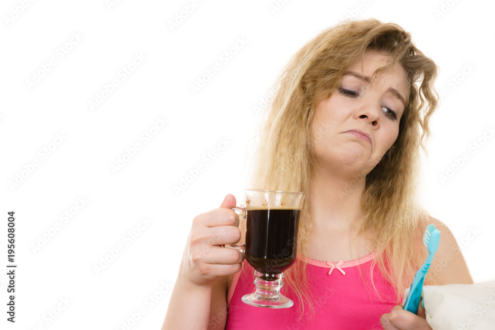 Tired woman holding toothbrush and coffee Tired woman holding toothbrush and coffee