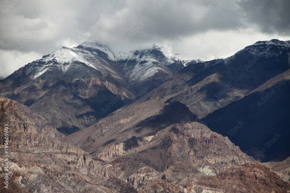 nagie częściowo ośnieżone i zatopione w chmurach szczyty górskie w andach w argentynie