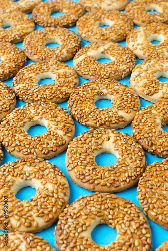 Round cookies with sesame seeds on a bright blue background.