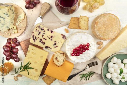 Various types of cheese with wine on a light background