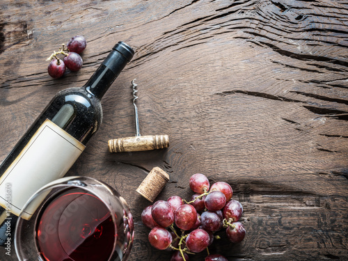 Wine glass, wine bottle and grapes on wooden background. Wine tasting.