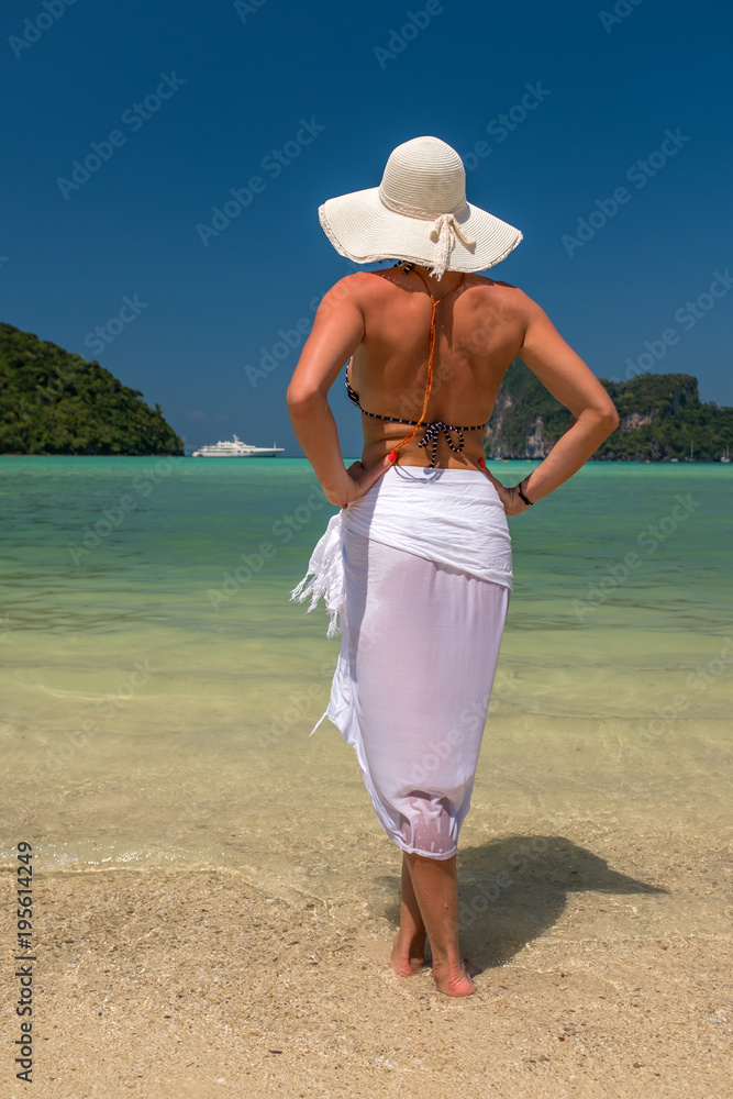  lady in black beachwear, floppy hat, sunglasses enjoying sun on tropical destination during summer vacation in Thailand