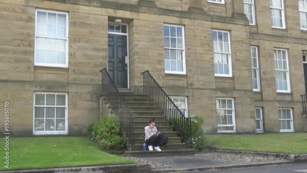 A girl sitting on a staircase of an old, beautiful building, with a lot of grass around it, Newcastle upon Tyne, UK A girl sitting on a staircase of an old, beautiful building, with a lot of grass around it, Newcastle upon Tyne, UK