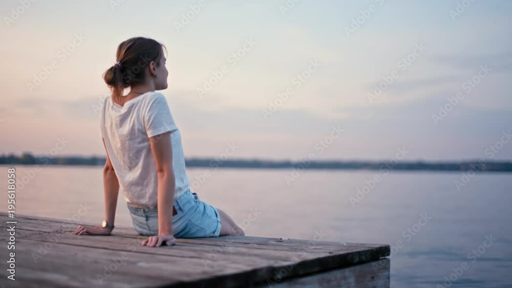Young Slender Woman is Enjoying Summer Sunset Glow near Lake and Relaxing. Amazing background for your motto Young Slender Woman is Enjoying Summer Sunset Glow near Lake and Relaxing. Amazing background for your motto