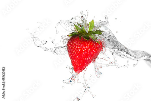 Water splashing on a strawberry against a white background
