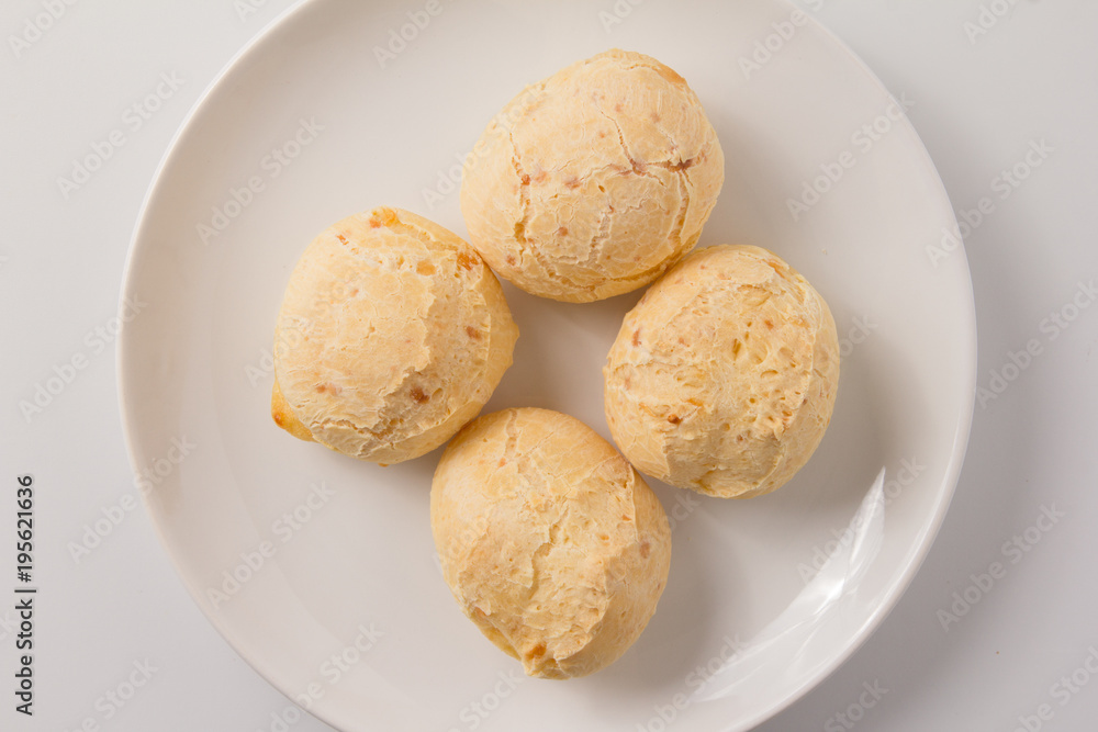 Pao de Queijo is a cheese bread ball from Brazil. Also known as Chipa, Pandebono and Pan de Yuca. Snacks over white plate, minimalism. Pao de Queijo is a cheese bread ball from Brazil. Also known as Chipa, Pandebono and Pan de Yuca. Snacks over white plate, minimalism.