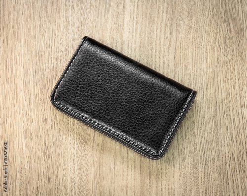 Black leather card holders on wooden background. Top view of Leather wallet for keep your money.