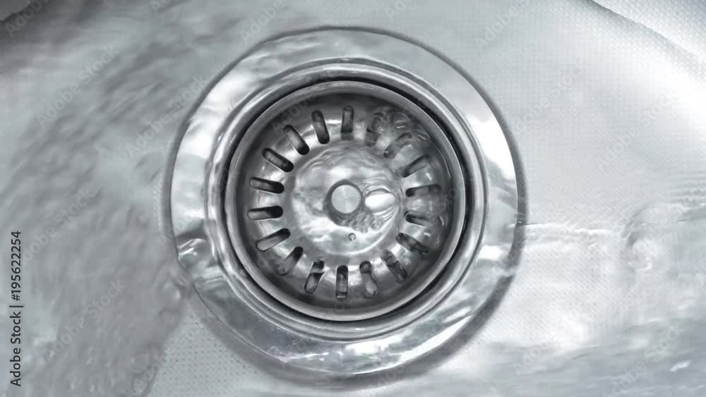Streaming water in sink. Water stream going down the drain.
Streaming water in sink. Water stream going down the drain.