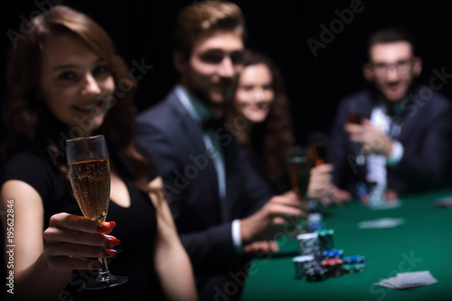 fashion woman with glasses of wine,sitting at a table in a casino