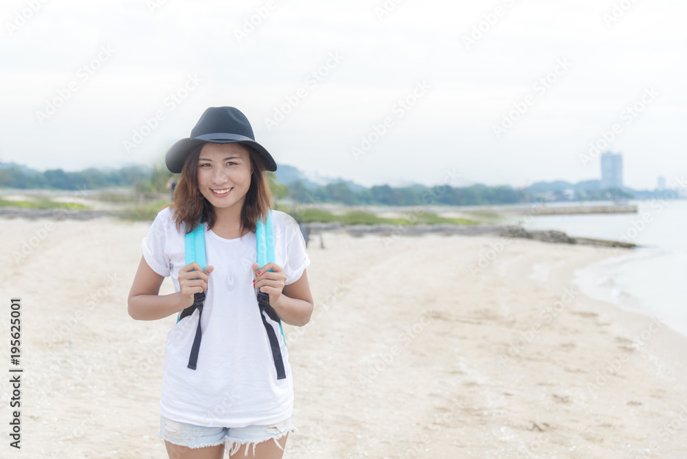 Young traveller woman with backpack look at camera. Woman sitting at the park and look at map. Travel Concept.
